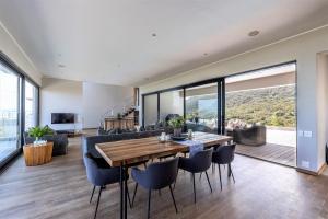 a dining room and living room with a table and chairs at Whaleshaven 14 in Plettenberg Bay