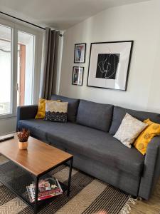 a living room with a gray couch and a table at Style et ambiance in Foix