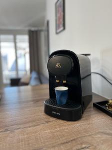 eine Kaffeemaschine mit einer Tasse auf dem Tisch in der Unterkunft Style et ambiance in Foix