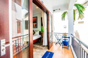 um quarto com uma varanda e uma cama em Relax Garden Boutique Villa Hoi An em Hoi An