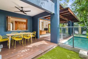 een terras met een tafel en stoelen en een zwembad bij The Savannah Villa in Port Douglas