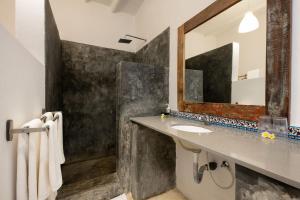 W łazience znajduje się umywalka i lustro. w obiekcie Fun Beach Hotel w mieście Jambiani