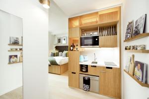 a kitchen with a sink and a microwave in a room at Wilde Aparthotels London Covent Garden in London