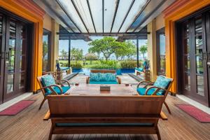 a patio with a table and chairs and a pool at Amertha Bali Villas in Pemuteran