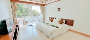 a bedroom with a large bed and a tv at Mam Kaibae Hotel in Ko Chang