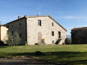 ein altes Steingebäude auf einem Grasfeld in der Unterkunft Appartamenti con cucina nelle colline toscane in Anghiari