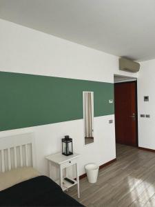 una camera da letto con parete verde e bianca di B&B Daniel a Lodi