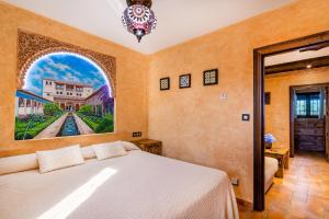 1 dormitorio con 1 cama y una pintura en la pared en Alpujarra Sulayr, en Pórtugos
