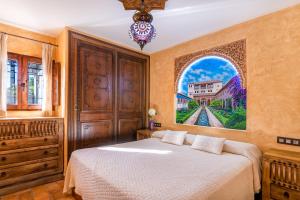1 dormitorio con 1 cama y una pintura en la pared en Alpujarra Sulayr, en Pórtugos