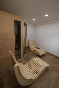 two wooden chairs in a room with a mirror at Apartments Emona FREE Parking-sauna-gym in Ljubljana