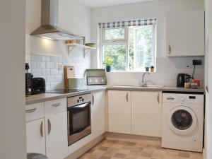 a kitchen with a sink and a washing machine at The Duck House in Wool