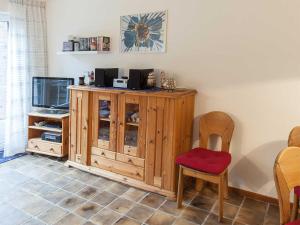 a room with a wooden cabinet and a red chair at Ferienhaus Kickler, FeWo Vermittlung Nordsee in Dangast