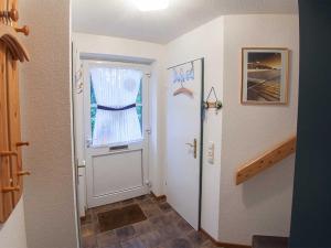 a hallway with a white door and a window at Ferienhaus Kickler, FeWo Vermittlung Nordsee in Dangast