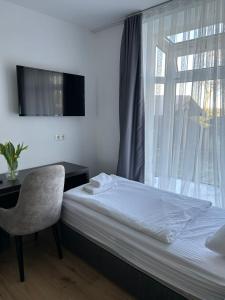 een slaapkamer met een bed, een stoel en een raam bij M & M Hotel in Oyten
