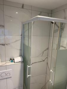 a shower with a glass door in a bathroom at M & M Hotel in Oyten