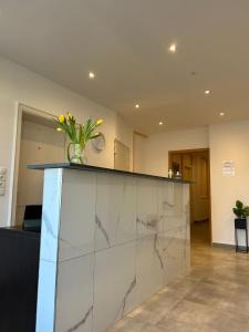 a lobby with a counter with a vase of flowers on it at M & M Hotel in Oyten