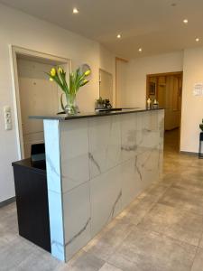 a lobby with a counter with a vase of flowers on it at M & M Hotel in Oyten