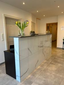 a lobby with a counter with a vase of flowers on it at M & M Hotel in Oyten +3 photos