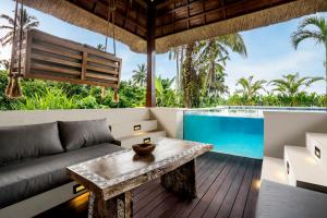 ein Wohnzimmer mit Sofa und Tisch in der Unterkunft Villa Tchikobo by BaliSuperHost in Ubud
