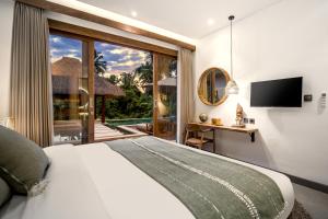 1 dormitorio con 1 cama y puerta corredera de cristal en Villa Tchikobo by BaliSuperHost, en Ubud