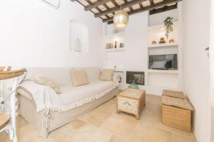 a living room with a white couch and a fireplace at Casa Manuela in Vejer de la Frontera
