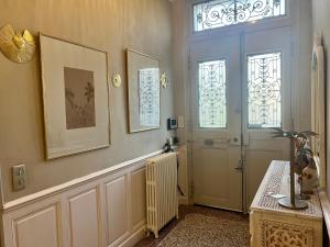 un couloir avec une porte, une fenêtre et un radiateur dans l'établissement Maison Douce Arles, à Arles