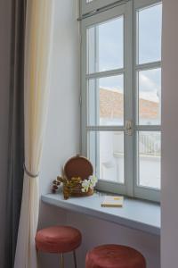 a window with two stools sitting next to a table at Residenza di Fedralia in Nafplio +87 photos
