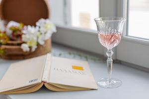 a book and a glass of wine on a table at Residenza di Fedralia in Nafplio