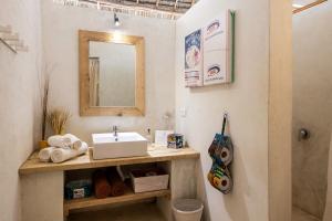 a bathroom with a sink and a mirror at The Loop Beach Resort in Jambiani