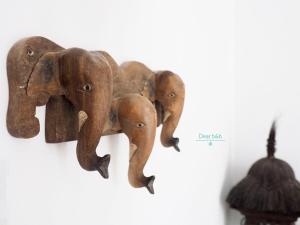 un groupe d'éléphants en bois suspendus sur un mur dans l'établissement Fas BnB, à Jiali