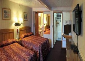 um quarto de hotel com duas camas e uma televisão em A1 Economy Inn em Somerset
