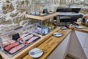 a counter with meat and other food on it at Hotel Berne Opera in Paris +78 photos
