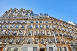 un grand bâtiment au milieu d'une rue dans l'établissement Hotel Berne Opera, à Paris