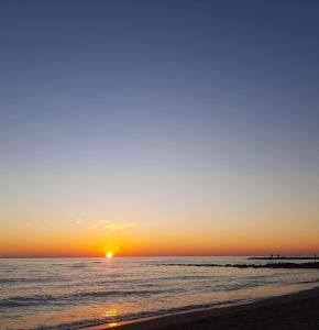 a sunset on the beach with the sun setting at la passeggiata in Lido di Ostia