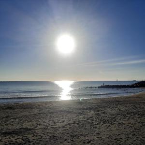 una playa con el sol saliendo sobre el océano en la passeggiata, en Lido di Ostia