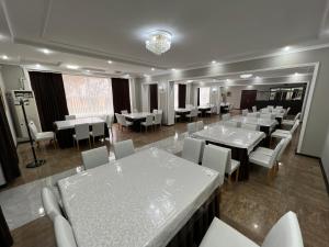 a dining room with white tables and white chairs at Яссы hotel, Turkistan in Türkistan