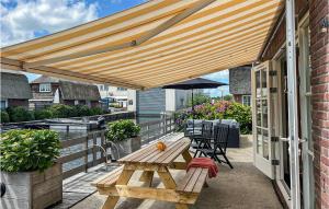 un patio con una mesa de picnic de madera y una sombrilla en Pet Friendly Home In Breukelen With House Sea View en Breukelen