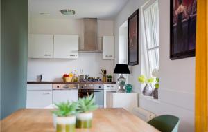 ブリューケレンにあるStunning Home In Breukelen With 3 Bedrooms And Wifiの白いキャビネットと木製テーブル付きのキッチン