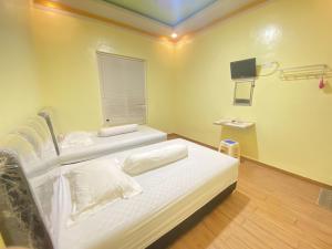a hospital room with two beds and a window at Homestay RN near Taman Bambu Runcing Polewali Mitra RedDoorz in Matakali +26 photos