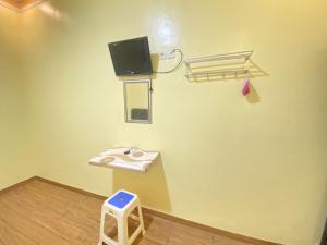 a room with a stool and a tv on the wall at Homestay RN near Taman Bambu Runcing Polewali Mitra RedDoorz in Matakali