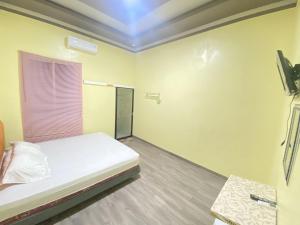 a small room with a bed and a window at Homestay RN near Taman Bambu Runcing Polewali Mitra RedDoorz in Matakali