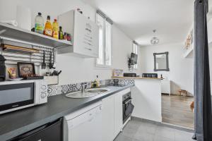 a kitchen with a sink and a microwave at Au coeur du triangle d'or de Versailles in Versailles