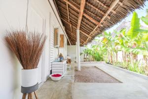 an outdoor room with a patio with plants at The Loop Beach Resort in Jambiani