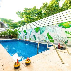 una piscina con un mural en el lateral de un edificio en Infinity Villa, 5BHK-Private Pool-Caretaker, Baga en Baga