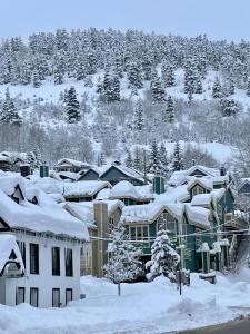 una ciudad cubierta de nieve con árboles y casas en Condo at The Park Hotel, en Park City