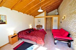 1 dormitorio con cama roja y sofá rojo en Domaine Lagardelle Rocamadour, en Rocamadour