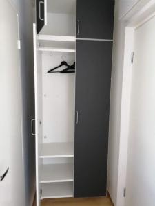 a closet with white shelves and a black door at Tyylikäs studio Helsingin sydämessä in Helsinki