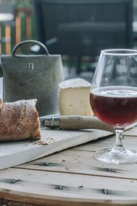 um copo de vinho sentado numa mesa com queijo e pão em CHALET HOTEL La TUVIERE BIKE INN em Saint-Jean-de-Maurienne