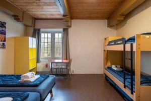 Pokój z 2 łóżkami piętrowymi i stołem w obiekcie Stayokay Hostel Heemskerk w mieście Heemskerk