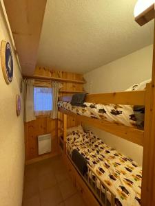 a bedroom with two bunk beds in a cabin at La forêt des Rennes in Villard-sur-Doron